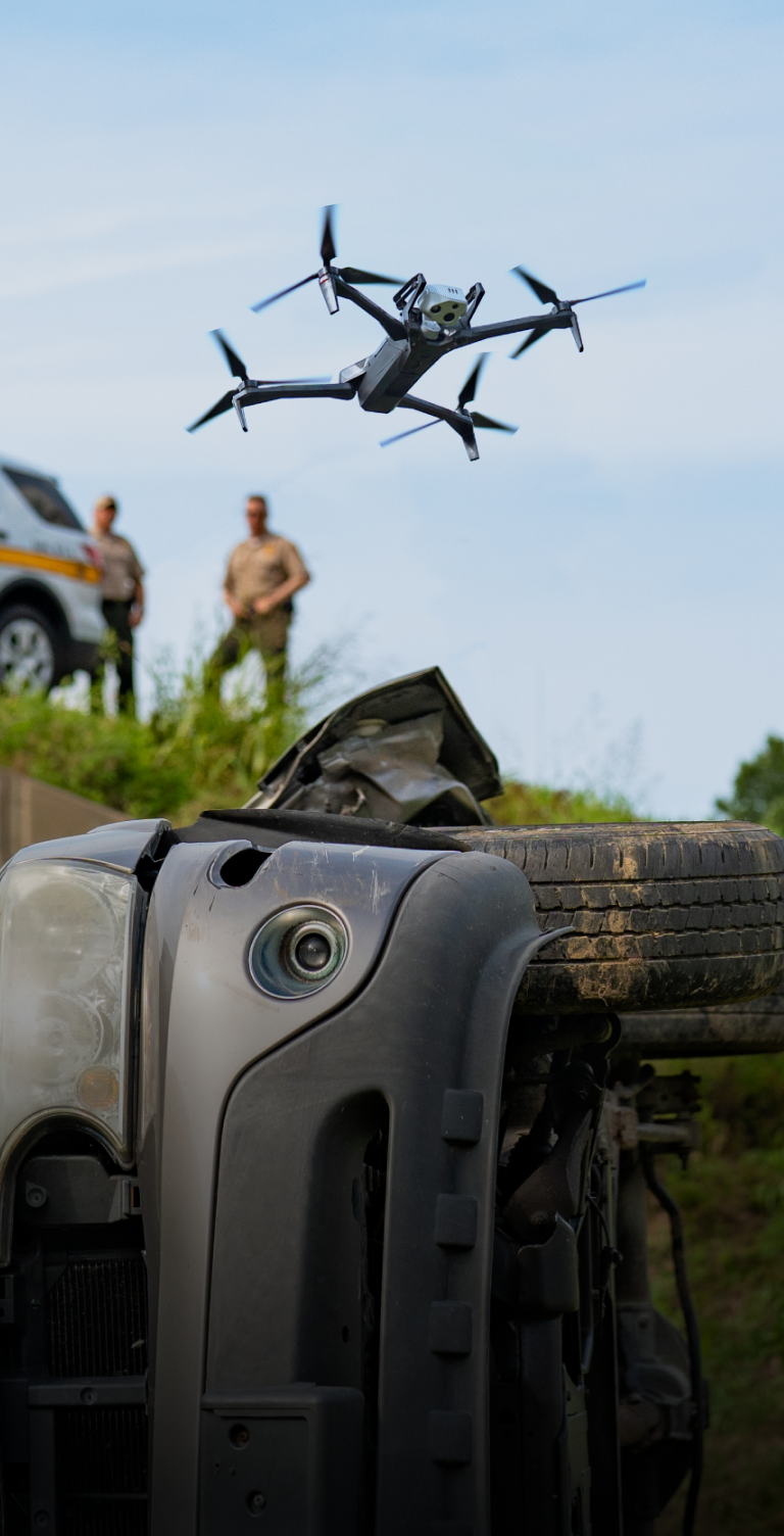 crashed vehicle with Skydio X10 drone with 3D Scan software flying above